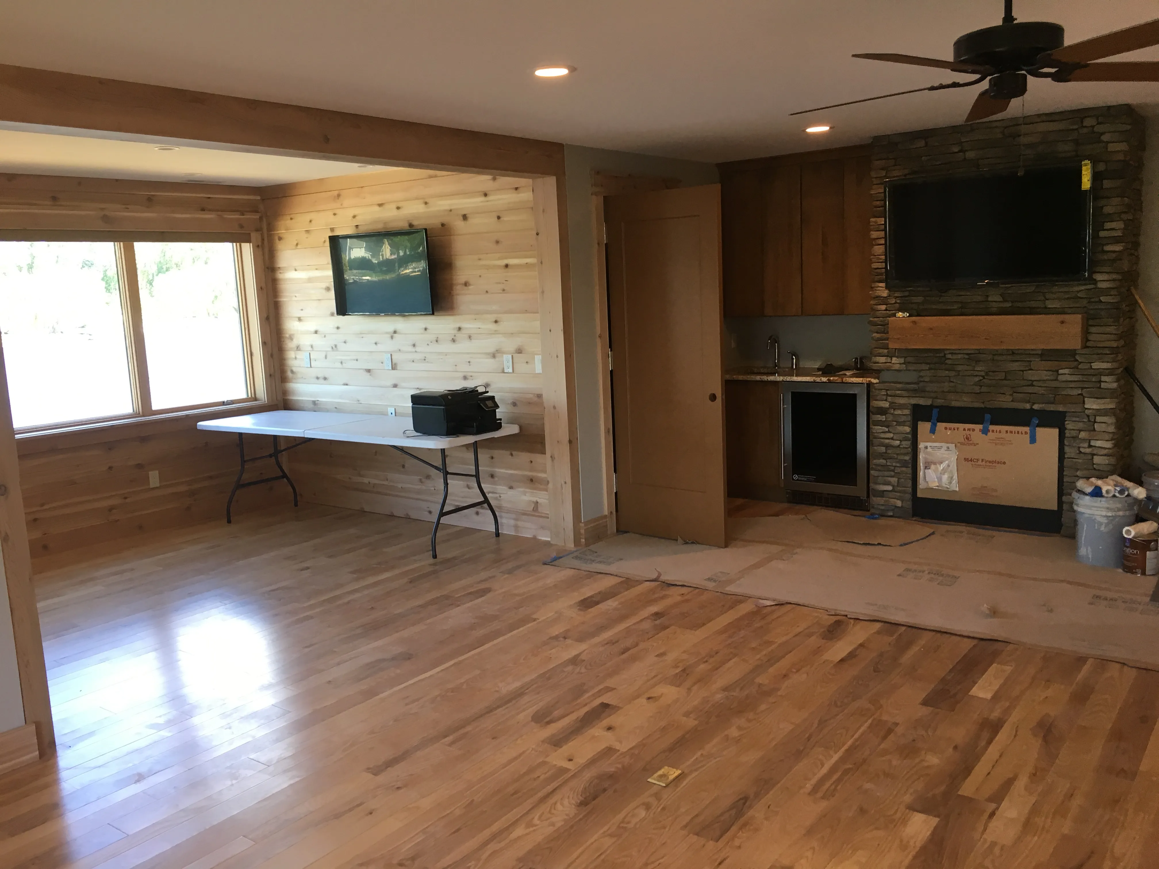 Wide view of the installation site with wall-mounted displays, lighting, and finished woodwork
