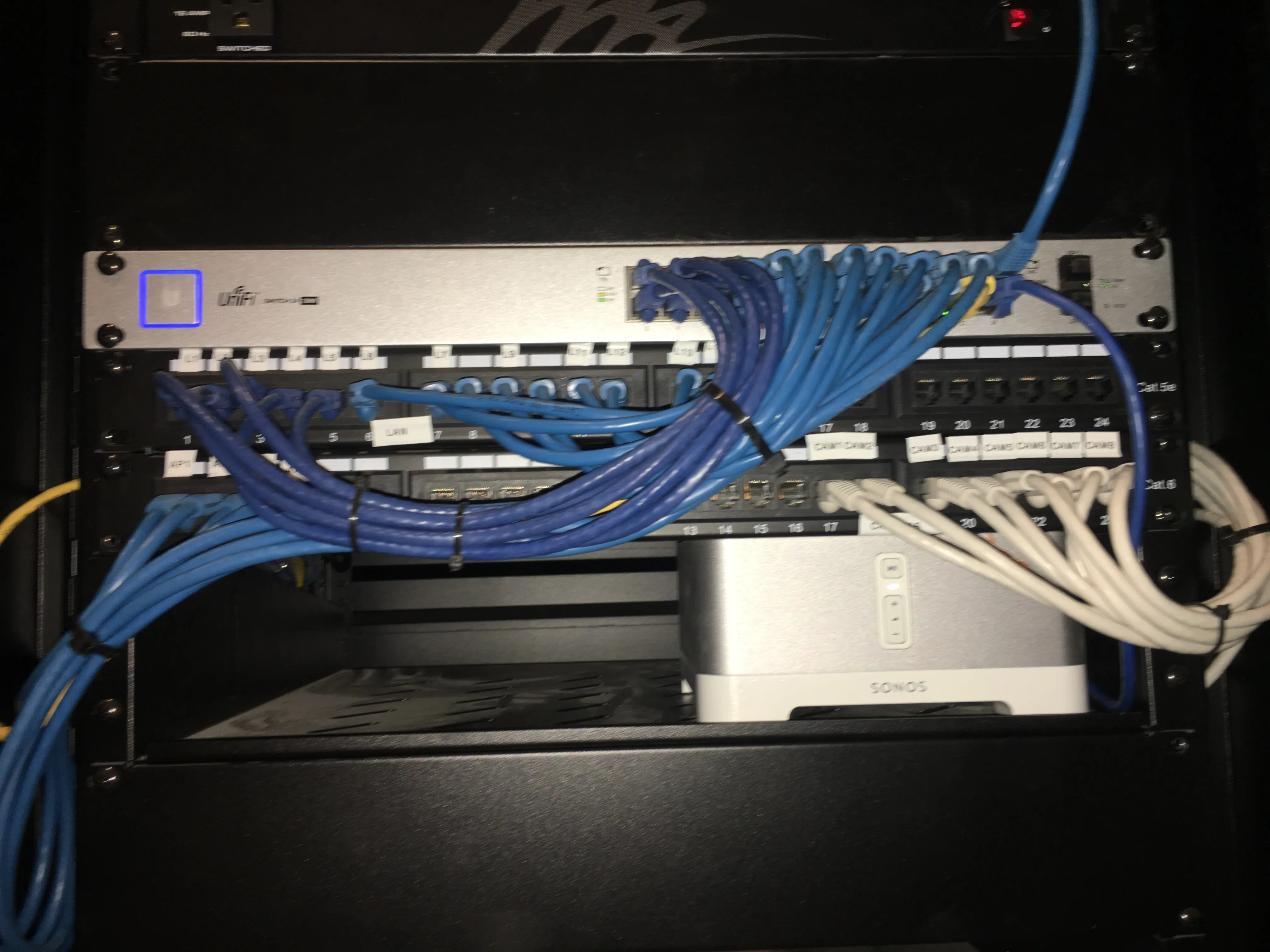Network switch, patch panels, and organized blue and white patch cables